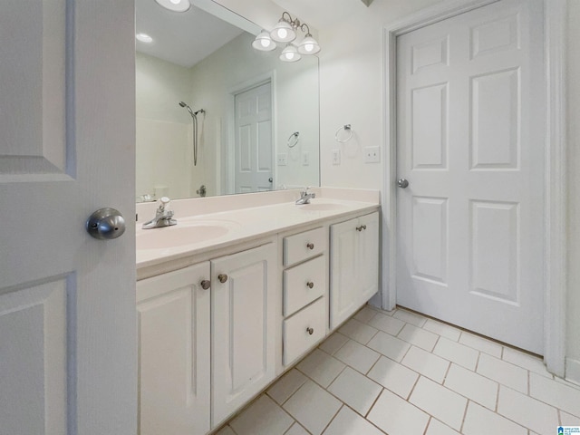 bathroom featuring tile patterned flooring, vanity, and walk in shower