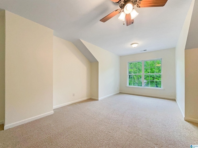 bonus room with ceiling fan and light colored carpet