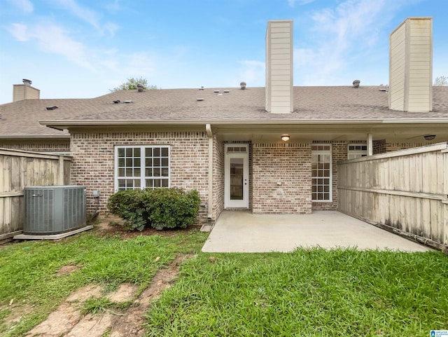 back of property with a patio, central AC, and a lawn