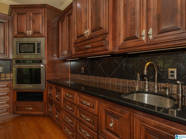 kitchen featuring sink, backsplash, light wood-type flooring, and stainless steel appliances