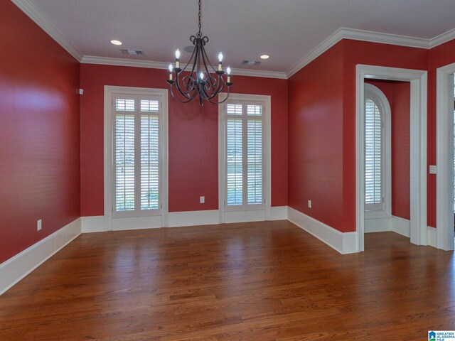 empty room with ornamental molding, an inviting chandelier, and dark hardwood / wood-style flooring