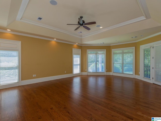 spare room with a tray ceiling, crown molding, wood-type flooring, and ceiling fan