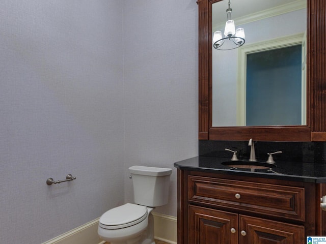 bathroom with vanity, toilet, and a chandelier