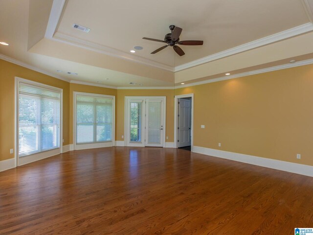 unfurnished room with ceiling fan, ornamental molding, a tray ceiling, and hardwood / wood-style flooring