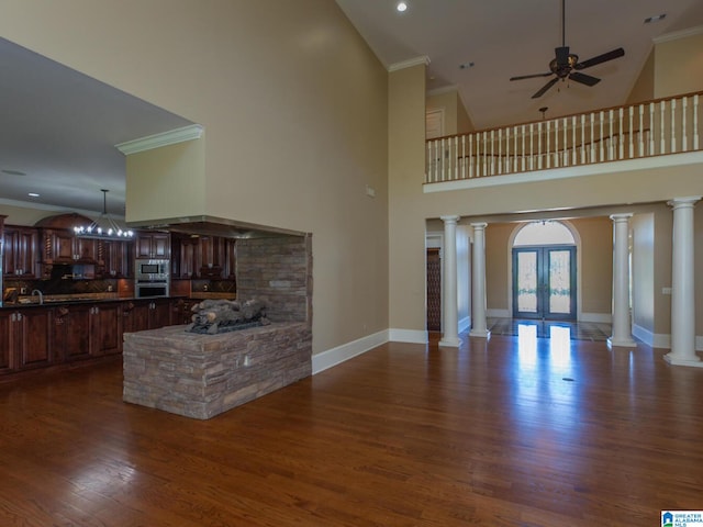 living room featuring hardwood / wood-style flooring, ceiling fan, ornamental molding, high vaulted ceiling, and ornate columns