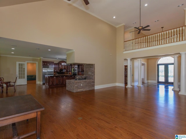 living room with french doors, wood-type flooring, ornate columns, high vaulted ceiling, and ceiling fan