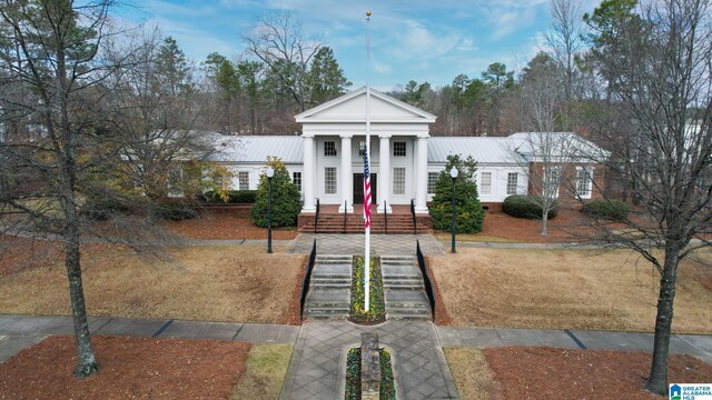 greek revival inspired property featuring a front lawn