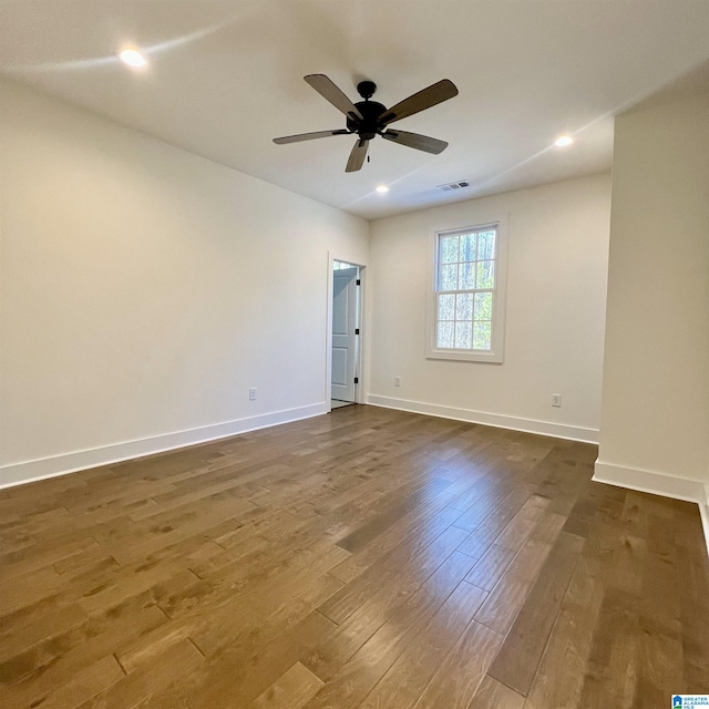 empty room featuring ceiling fan and dark hardwood / wood-style flooring