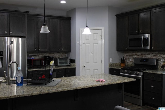 kitchen with backsplash, a toaster, appliances with stainless steel finishes, and a sink