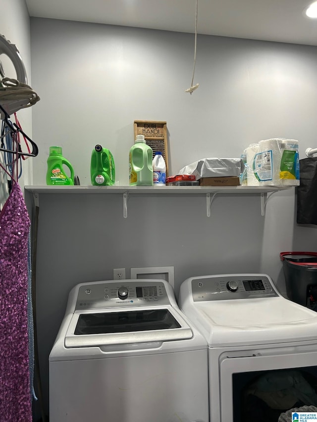 clothes washing area featuring laundry area and washer and clothes dryer