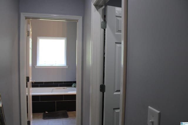 bathroom featuring tiled bath and tile patterned flooring