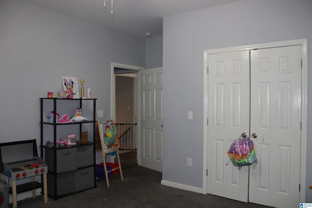 game room featuring baseboards and dark colored carpet