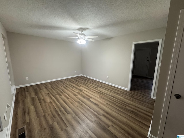 unfurnished bedroom featuring a textured ceiling, dark wood finished floors, visible vents, and baseboards