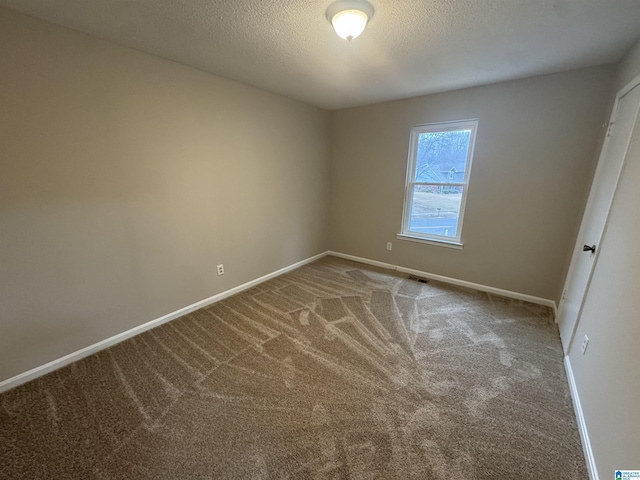 unfurnished bedroom with carpet floors, a textured ceiling, and baseboards