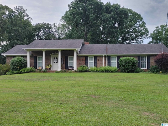 ranch-style house with a front yard and covered porch