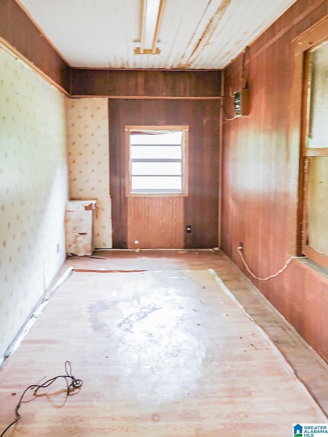 empty room featuring hardwood / wood-style flooring and wooden walls