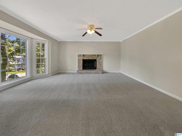 unfurnished living room with carpet floors, a brick fireplace, ceiling fan, and ornamental molding