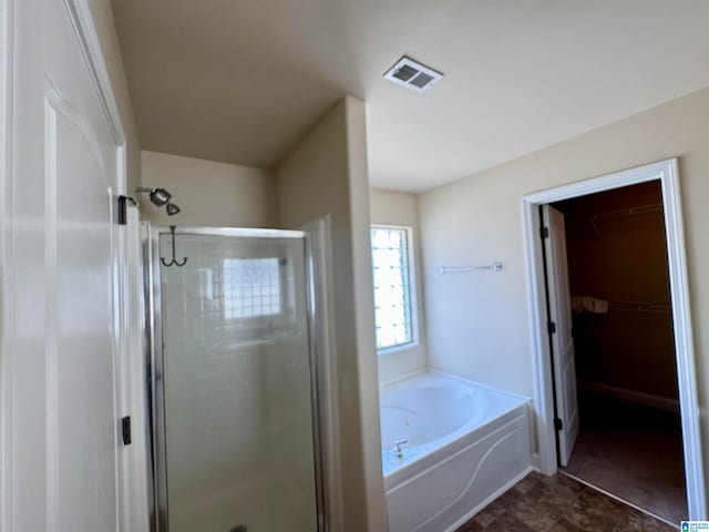 bathroom with tile flooring and shower with separate bathtub