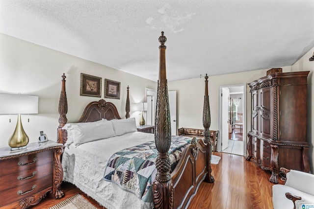 bedroom with light wood-type flooring and a textured ceiling