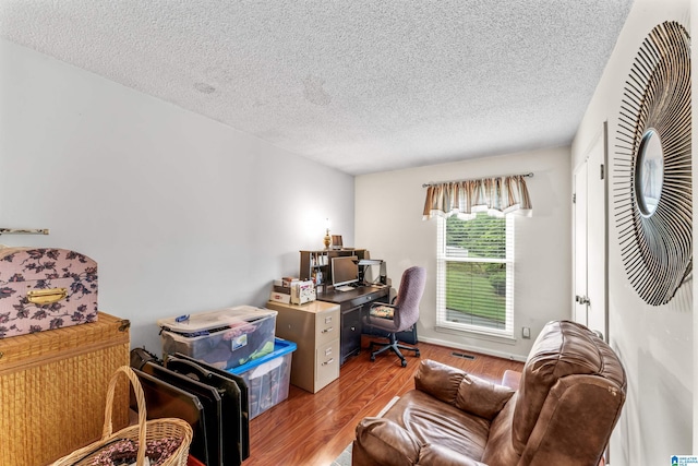 office area with a textured ceiling and hardwood / wood-style floors