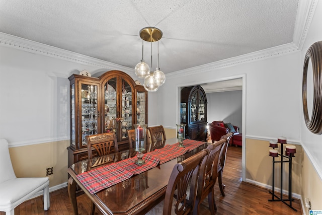 dining space with dark wood-type flooring, a textured ceiling, and ornamental molding