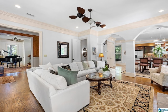 living room with hardwood / wood-style floors, crown molding, and a healthy amount of sunlight