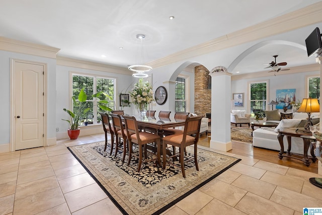 tiled dining room with ceiling fan, ornamental molding, and decorative columns