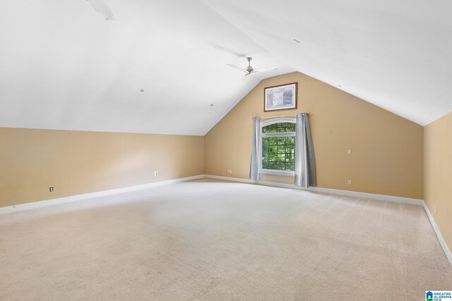 bonus room with light colored carpet and vaulted ceiling