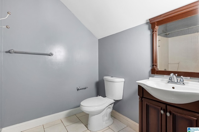 bathroom with tile patterned floors, toilet, vaulted ceiling, and vanity