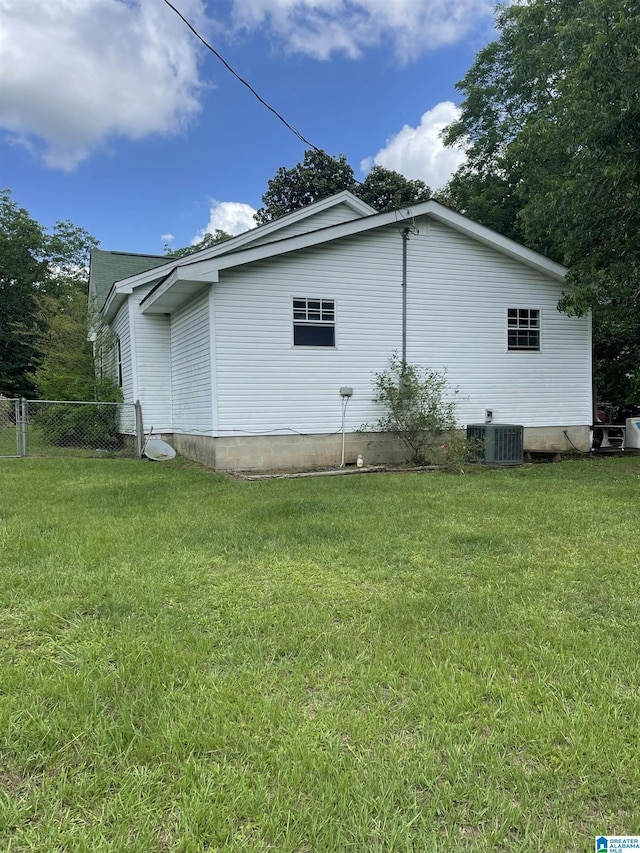 view of side of home featuring a lawn and cooling unit