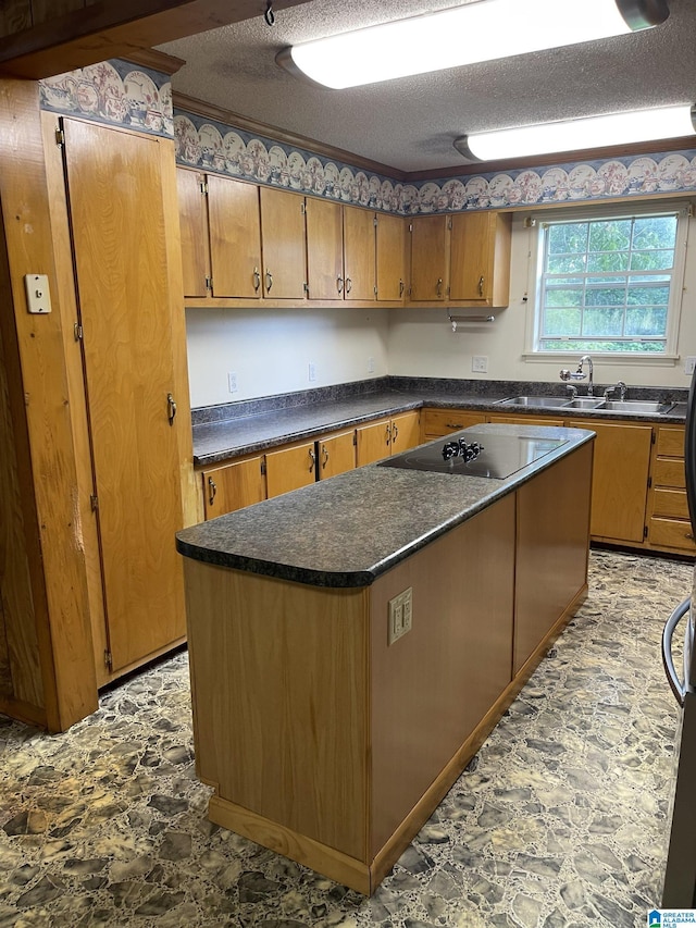 kitchen featuring sink, a kitchen island, a textured ceiling, and black electric stovetop