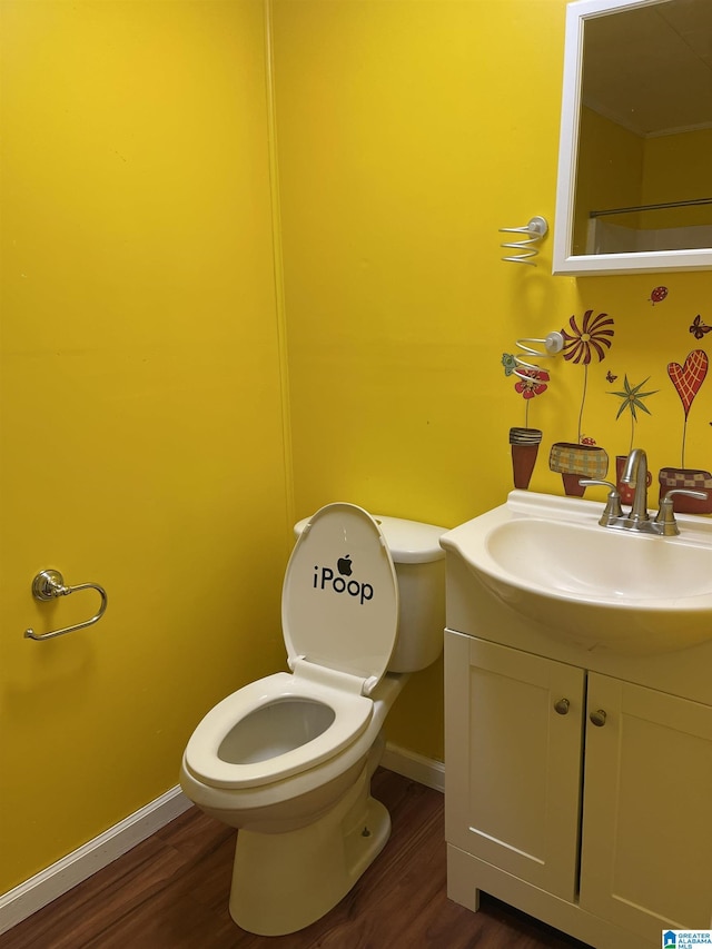 bathroom with toilet, vanity, and hardwood / wood-style flooring