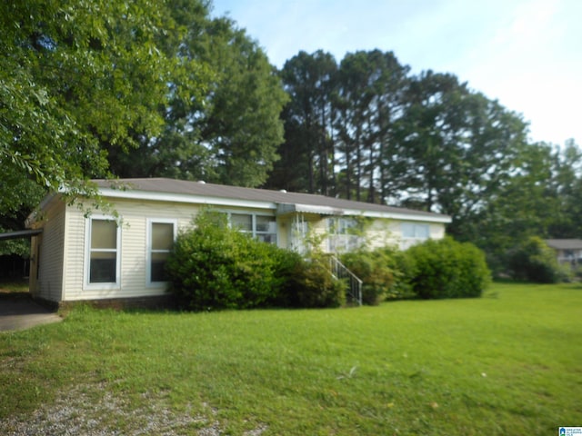 view of front of property featuring a front lawn and an attached carport