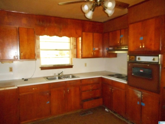 kitchen with wall oven, electric stovetop, a sink, light countertops, and brown cabinets