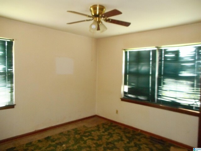 unfurnished room with baseboards and a ceiling fan