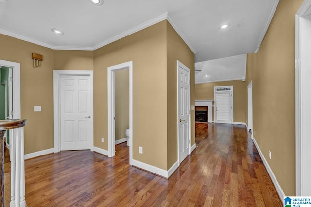 hallway with hardwood / wood-style flooring and ornamental molding