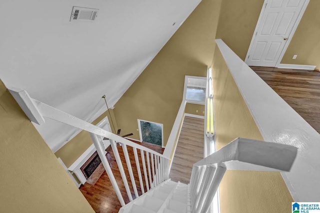 stairs featuring vaulted ceiling, hardwood / wood-style floors, and ceiling fan