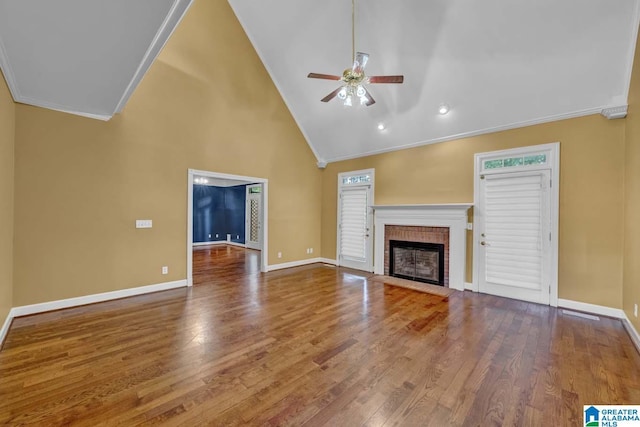 unfurnished living room with crown molding, high vaulted ceiling, hardwood / wood-style flooring, ceiling fan, and a fireplace