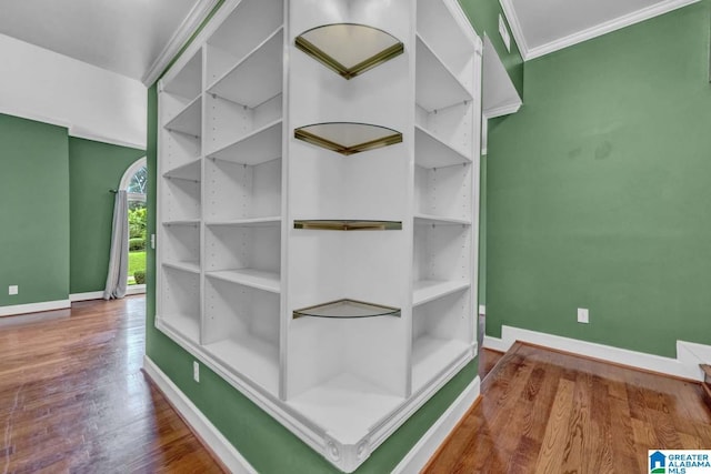 room details with hardwood / wood-style flooring, ornamental molding, and built in shelves