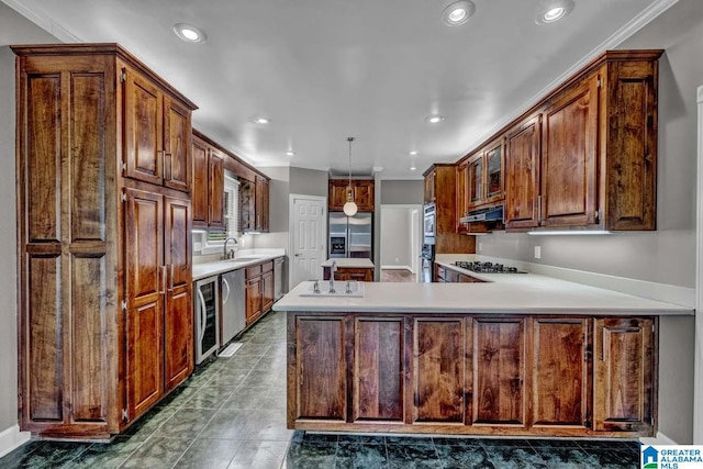 kitchen featuring sink, crown molding, hanging light fixtures, stainless steel appliances, and kitchen peninsula