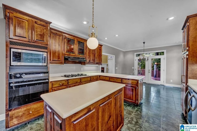 kitchen with a kitchen island, stainless steel microwave, oven, and decorative light fixtures