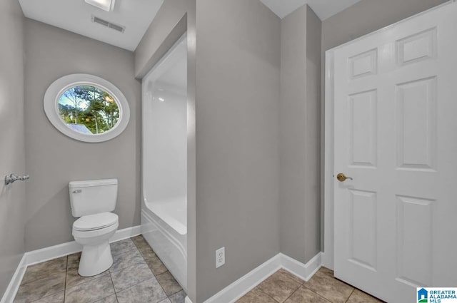 bathroom featuring toilet, a bathing tub, and tile patterned flooring