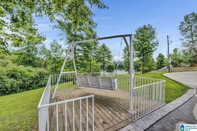 deck with a yard and a water view