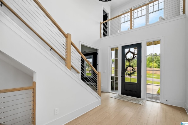 foyer entrance with light hardwood / wood-style floors and a high ceiling