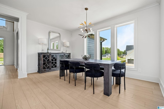 dining room featuring crown molding, plenty of natural light, a chandelier, and light wood-type flooring