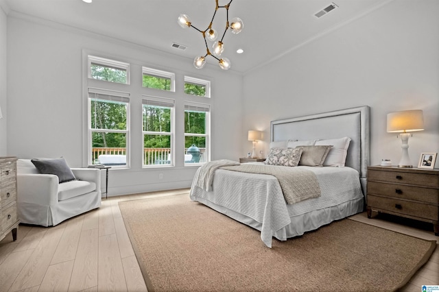 bedroom with an inviting chandelier, ornamental molding, and light wood-type flooring