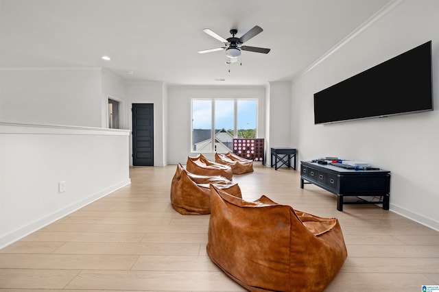 living room featuring crown molding, ceiling fan, and light hardwood / wood-style floors