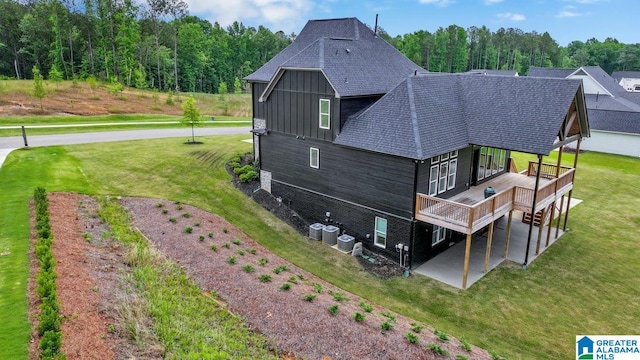 rear view of property featuring a patio area, central AC unit, a deck, and a lawn