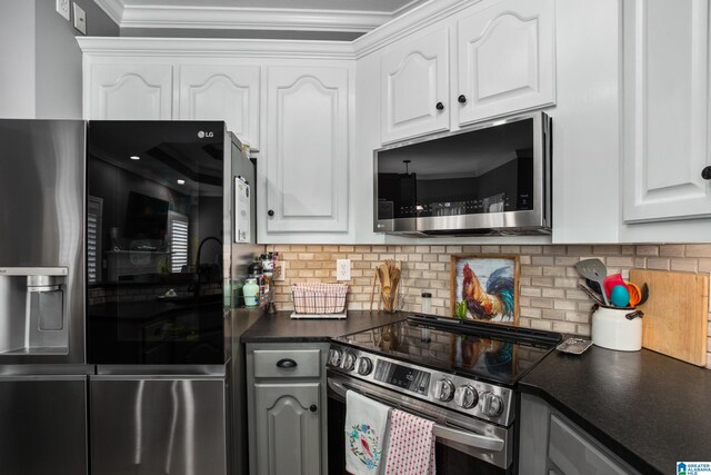 kitchen with backsplash, crown molding, stainless steel appliances, and white cabinets