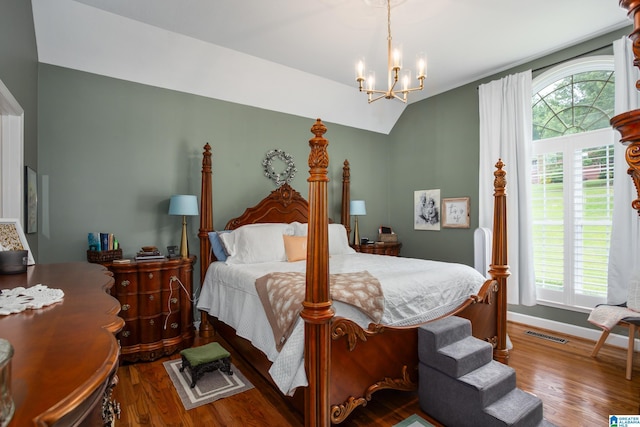 bedroom with an inviting chandelier, vaulted ceiling, and hardwood / wood-style floors